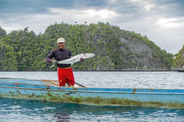 En fiskare från Gamfi med sin fisk fångad med rev. /This fisherman has caught a big fish with angling.